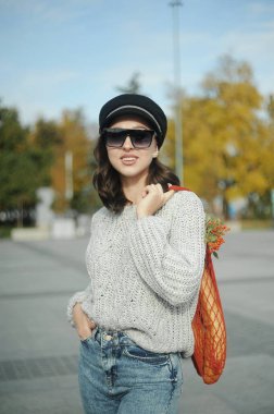 Açık havada turuncu kazaklı güzel bir kadın.