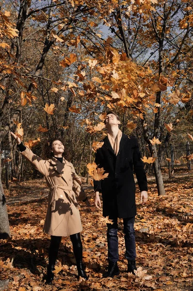 Young man in dark coat and woman in trendy beige coat