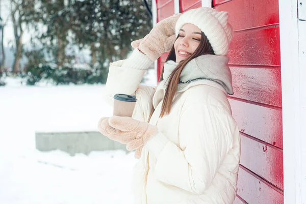 微笑的年轻女子在雪地的森林里喝咖啡 — 图库照片