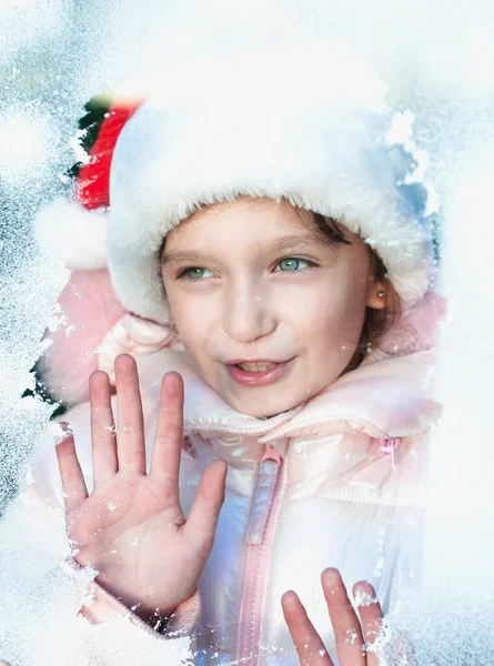 Girl Santa Claus Costume Looking Throught Snowy Window — Fotografia de Stock