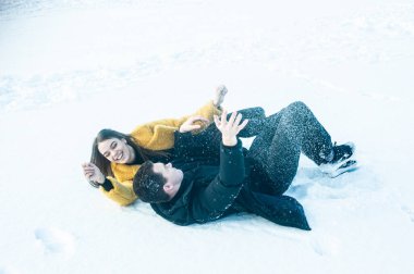 happy couple playing with snow on ice