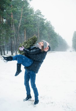young couple in love hugging and having fun at the winter park