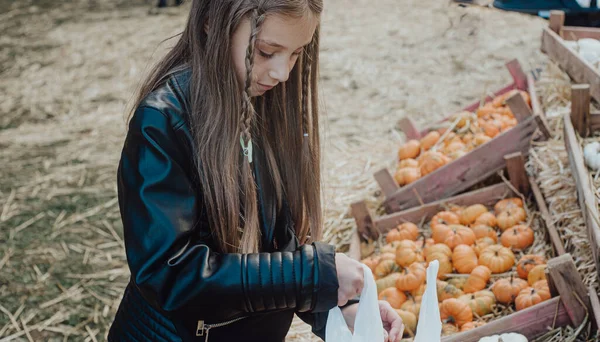 girl with a pumpkin on autumn market