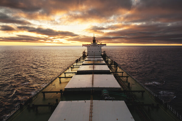 Cargo ship underway at sunset
