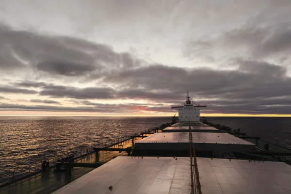 Cargo ship underway at sunset — Stock Photo, Image