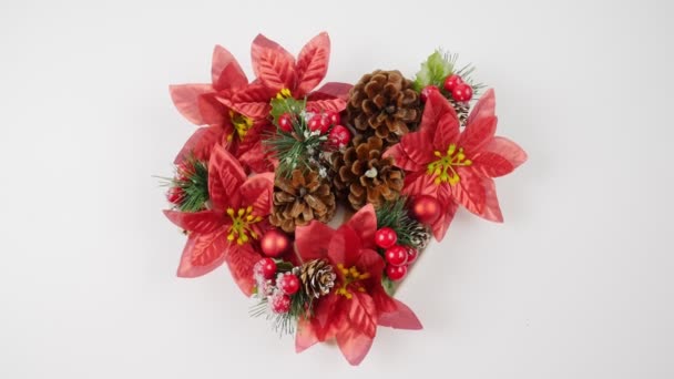 Christmas. Christmas decoration. Spruce cones and branches, red berries. Christmas red flower. Heart view — Stock Video
