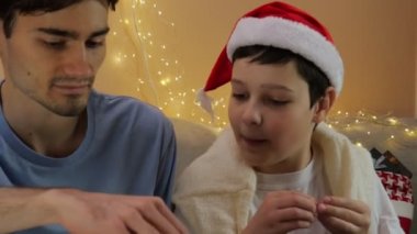 İki adam Noel için bir oyun oynuyorlar. Oyun Noel 'i. Noel Baba şapkası. Yaşam tarzı. Aile kutlaması. Oynayın. Masa oyunu. Yakın plan.