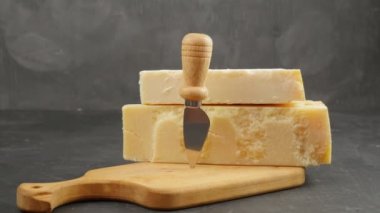 Parmesan peyniri. İki çeşit parmesan. Parmesan bıçağı. Tahtada parmesan peyniri var. 24 ay 48 ay