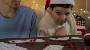 Noel Baba şapkalı iki mutlu adamın Noel Tatili Portresi. Çocuklar gerçek bir oyun oynuyorlar. Piyango. Noel zamanı. Burada.