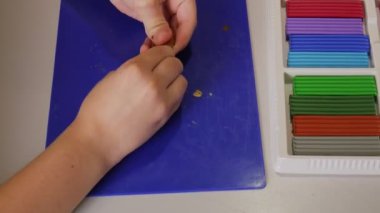 Çocuk plastikten el yapımı bir zanaat yapıyor. Plastik adam.