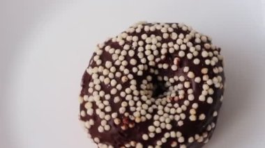 Beyaz arka planda çikolatalı çörek. Çöreğe beyaz toz serpilmiş.