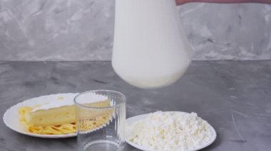 Süt. Süt ürünleri. Peynir ve süt bir bardağa doldurulur.