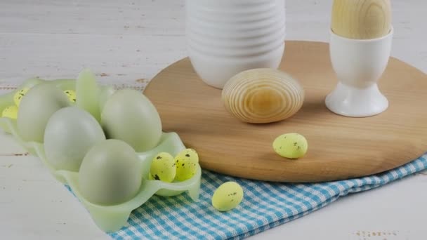 Diseño de cocina de Pascua. La naturaleza muerta de los huevos y la tabla de madera de la cocina sobre el fondo blanco. en primer plano. espacio de copia — Vídeos de Stock