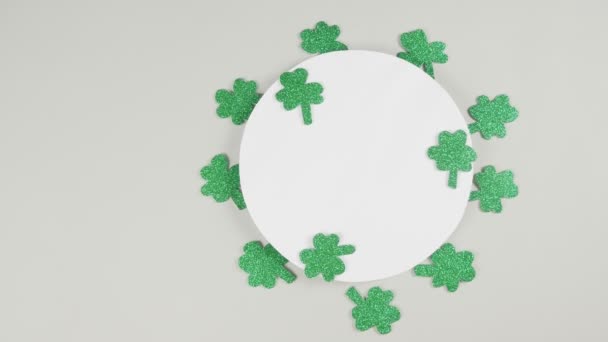 St. Patricks Day shamrocks op een grijze achtergrond. Zicht van bovenaf. Begrepen, ruimte. 4K — Stockvideo