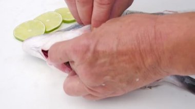 Dorado balığı. Şef Dorado 'yu hazırlıyor. Baharatlı çiğ dorado balığı. Limon ve yeşillik. Şef balığı hazırlar.