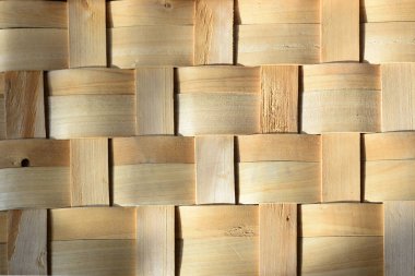 Birbirine dolanmış ahşap şeritler sepetin dibini oluşturuyor.