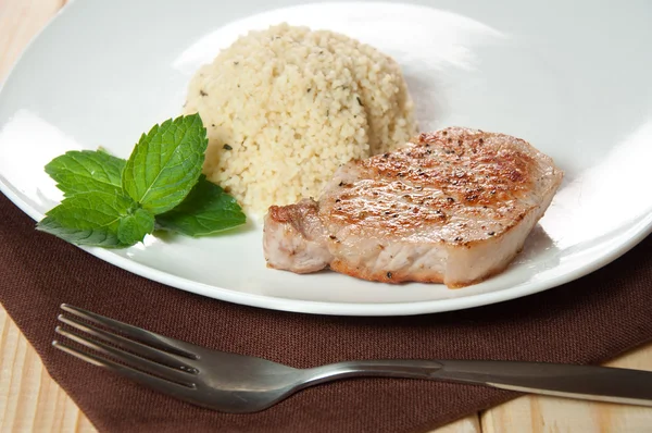 Carne de ternera frita con cuscús en el plato blanco — Foto de Stock