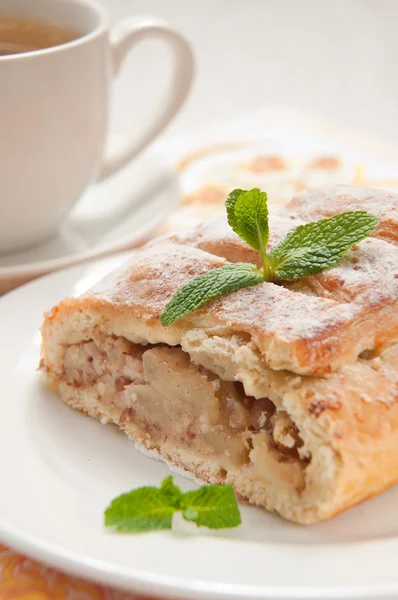 Slice of an apple strudel with tea — Stock Photo, Image