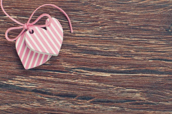 Corazones rosados sobre tabla de madera con cinta rosa — Foto de Stock