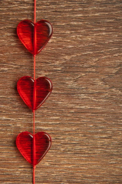 Trois cœurs rouges sur une planche en bois — Photo