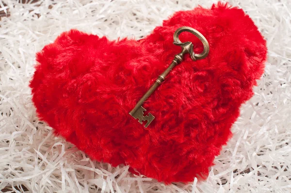 Red toy heart on white paper wih the key — Stock Photo, Image