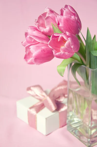 Rosa tulpaner i vasen med rutan gåva — Stockfoto
