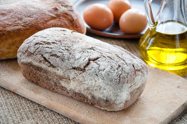 Homemade bread ciabatta on the table. Olive oil, eggs and flour — Stock Photo, Image