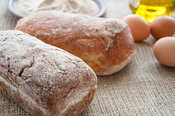 Homemade bread ciabatta on the table. Olive oil, eggs and flour — Stock Photo, Image