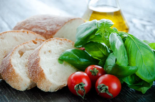 Bruschetta összetevők előkészítése: ciabatta, olaj, paradicsom, fokhagyma, bazsalikom — Stock Fotó