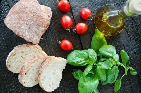 Bruschetta Zutaten für die Zubereitung: Ciabatta, Öl, Tomaten, Knoblauch, Basilikum — Stockfoto