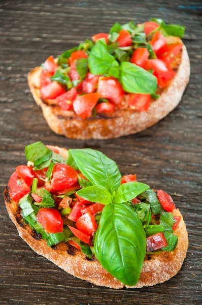 Olasz paradicsomos bruschetta-val apróra vágott zöldségekből, gyógynövényekből és grillezett vagy pirított héjas ciabatta a olaj — Stock Fotó