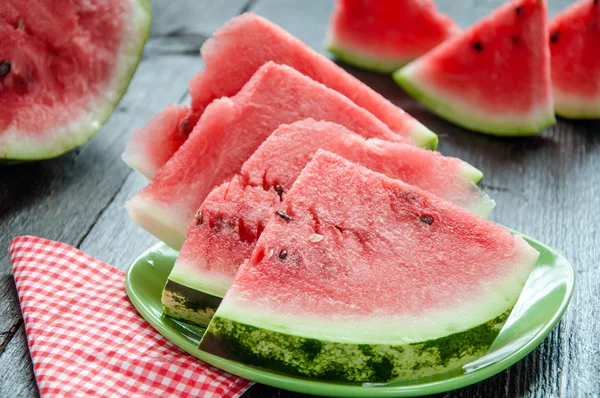 Reife Wassermelonen auf dem Tisch auf dem hölzernen Hintergrund — Stockfoto
