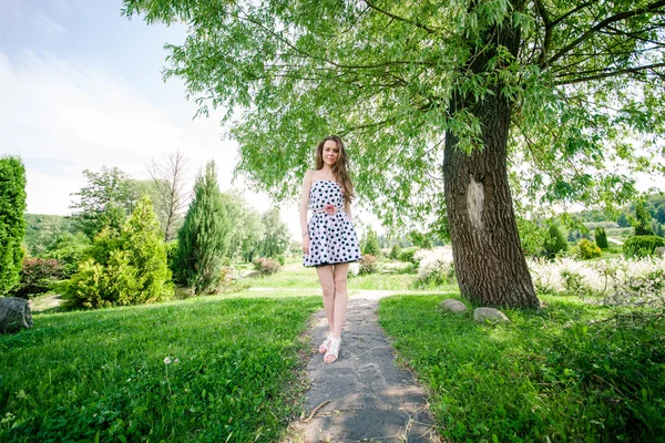 Beautiful young woman walking in the park — Stock Photo, Image