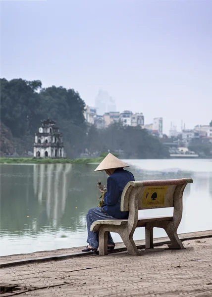 Vietnami Hanoi - március 2012: nő ül a padon — Stock Fotó