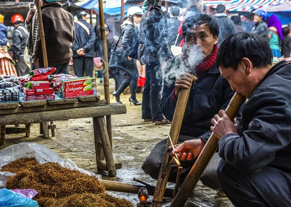 Oświetlenie i palenie tytoniu w tradycyjnych długich rur w niedzielę rynku. — Zdjęcie stockowe