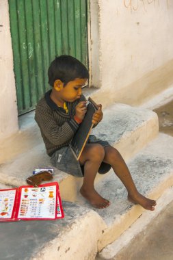 Hindistan khajuraho - Şubat 2011 - barefoot çocuk onun devlet okulu chalc küçük bir tahta üzerine ile çizilmemesi adımlar.