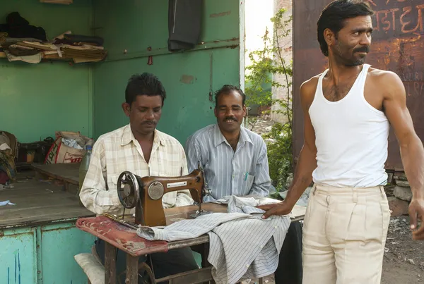 India Khajuraho - 23 febbraio 2011 - Sarto che lavora la sua macchina da cucire di fronte a una piccola cabina di strada . — Foto Stock