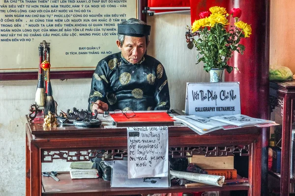 Старик предлагает каллиграфию в храме Нгок Сон, Ханой . — стоковое фото