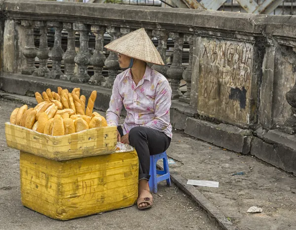 Jovem mulher vendendo pão fresco assado na rua . — Fotografia de Stock