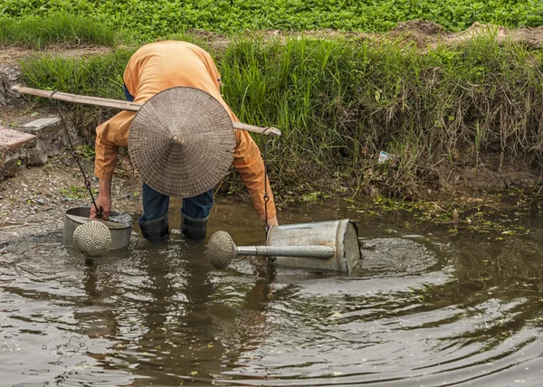 Agricultora llena dos latas de agua en la piscina . —  Fotos de Stock