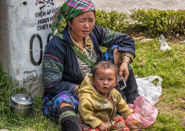 Hmong anne ve hücre ile yol kenarında oturan çocuk — Stok fotoğraf