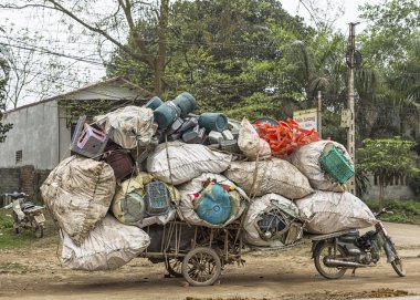 Motosiklet artı sepeti ile geri dönüşümlü plastik yüklü.