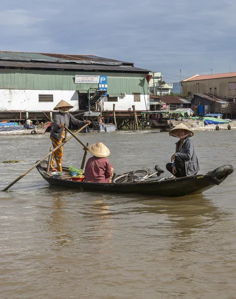 Mujer transporta a otras dos mujeres en su pequeño bote de remos . — Foto de Stock