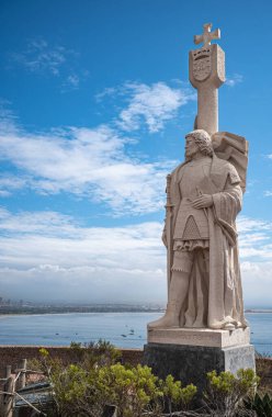 San Diego, California, ABD - 5 Ekim 2021: Bej taşından Cabrillo Ulusal Anıtı Ufukta mavi bulutların altında ve önünde yeşil bir bitki örtüsü var.