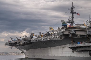 San Diego, California, ABD - 4 Ekim 2021: USS Midway Müzesi, Uçak Gemisi. İskele tarafındaki donanma rıhtımında gri bulutlu bölgeye kenetlenmiş gemi..