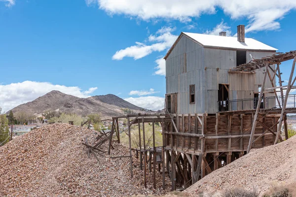 Tonopah Nevada 2011年5月18日 Historical Mining Park 青色の雲の下でストリップまたは廃棄物岩の2ベージュ茶色のヒープの間のピット上の灰色の段ボール金属板の建物 — ストック写真