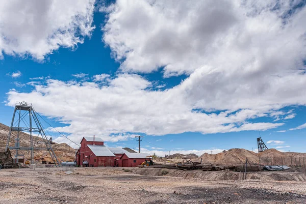 Tonopah Nevada 2011年5月18日 Historical Mining Park シャフトエレベーター塔と茶色ベージュ砂漠床の青い雲の下の赤い木造建築物と部品の風景 — ストック写真