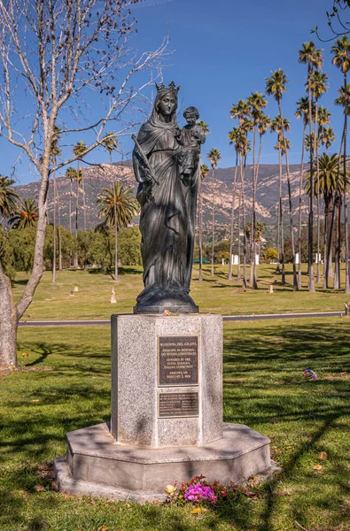 カリフォルニア州サンタバーバラ 2022年2月8日 カルバリー墓地 マドンナ グラッパ暗いブロンズ像台座の上に設定されています緑の埋葬芝生の上に青空の下でサンタYnez山の後ろに — ストック写真