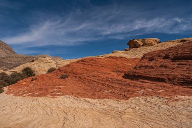 Las Vegas, Nevada, ABD - 23 Şubat 2010 Red Rock Canyon Conservation Area. Akan kırmızı ve bej kayalar mavi bulutların altında eğimli plato oluşturur..