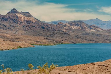 Nelson, Nevada, ABD - 21 Mayıs 2011: Mavi Colorado Nehri 'nin her ikisi de kuru çöl kıyıları. Arizona 'daki dağlar ve yeşil otlar renk katar.